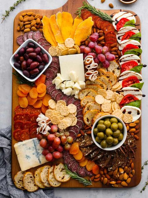 This classic Italian Charcuterie board is the perfect blend of savory and sweet. Loaded with nuts, dried fruit, cured meats, and a Caprese salad, this charcuterie board is perfect for your next get-together! Italian Charcuterie Board, Italian Charcuterie, Veggie Board, Charcuterie Party, Best Salads Ever, Charcuterie Appetizers, Charcuterie Ideas, Gourmet Grilled Cheese, Entertaining Food