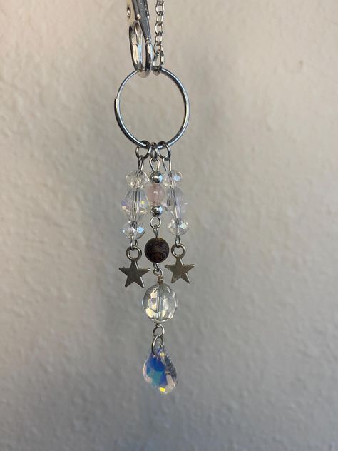 Our handmade Enchanted Car Charm is both stylish and versatile featuring star themed charms, glass crystal beads, and acrylic beads. Made from durable and sustainable silver chain with a sturdy claw clasp, this cute car charm is designed for longevity. Measure approx. 7"-9" long when hanging A great gift idea for all occasions, get your Enchanted Car Charm handmade for that special someone today! **Because we believe that handmade treasures are the ones that hold the most sentiment, each piece is lovingly crafted by hand so some variances may occur from what is pictured, making it an extra special piece to cherish forever. Car Mirror Hanger, Witch Bells, Crystal Car Charms, Car Mirror Hangers, Hanger Decor, Car Hangers, Mirror Hangers, Car Charms, Cute Cars