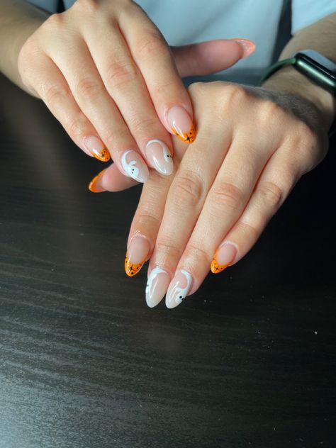 Ghost accents with an orange french tip and black stars Short Almond Halloween Acrylic Nails, Orange French Tip Halloween Nails, Orange Halloween Nails Acrylic, White And Orange Nails Acrylic, Halloween Ghost Nails, Orange French Tip, Reverse French Nails, Fall Almond Nails, Ghost Nails