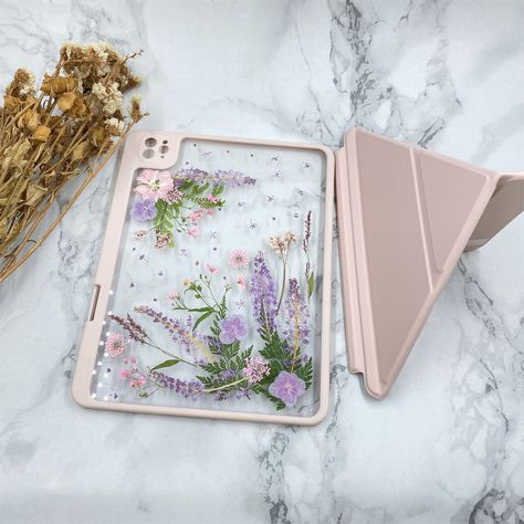 "These iPad cases are crafted from 100% real dried flowers,high quality clear back cover and resin case. Each case needs to be specially molded so the pressed flowers can be placed on the case.  Flowers are natural genuine flowers with variety of beautiful colors and they are dried and pressed.  I will try my best to make the same flower case as the photo you order. However, sometimes a bit of difference. There will be some differences in the shape and color of the flowers because of different s Ipad Cases Aesthetic, Ipad Cover Aesthetic, Ipad Case Aesthetic, Ipad 10th Gen, Cute Ipad Cases, Resin Case, Navigation Design, Pencil Storage, Grass Flower