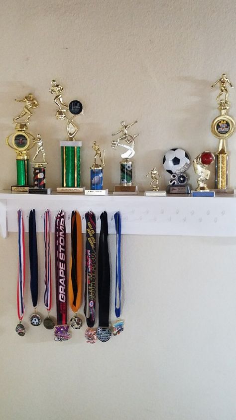 Trophy and medal shelf Awards Shelf Ideas, Trophy Shelf Ideas Interior Design, Medal Shelf, Trophy Display Ideas, Award Shelves, Trophy Display Shelves, Toy Collection Room, Skateboard Room, Trophy Shelf