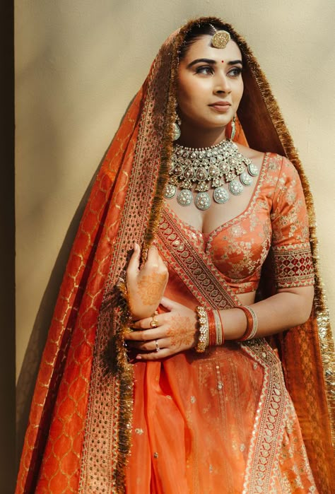 Photo of unique bridal jewellery with an orange lehenga Orange Pink Bridal Lehenga, Red Orange Bridal Lehenga, Orange Red Bridal Lengha, Indian Bridal Photos Wedding Dresses, Unique Bridal Looks Indian, Orange Wedding Lehenga Indian Bridal, Rust Wedding Lehenga, Indian Bridal Lehenga Pastel, Burnt Orange Bridal Lehenga