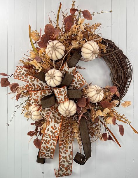 This neutral fall wreath is made on a grapevine base that is adorned with neutral color pumpkins, fall greenery, and coordinating fall ribbon.   The tan and cream colors of this wreath are gorgeous and sure to bring a fresh fall look to your home or porch!  Wreath Measurements: 21"W x 38"H (including ribbon) x 8"D Ready to 📦 and 📬 to YOU today! 😎 **FREE SHIPPING IS OFFERED FOR LOWER 48 US STATES ONLY** 💕 I use high quality materials and put a special touch of TLC in every wreath I design. My wreaths are ideally suited for an indoor or covered outdoor setting. 🛍 Visit Up North Wreath Designs @ www.UpNorthWreathDesigns.etsy.com to see other wreaths available in my shop. ❤️ "Favorite My Shop" to get updates on new wreath designs and for quick access for browsing convenience. 🎀 Portion o Fall Ribbon Wreath, Cornucopia Centerpiece, Front Door Rustic, Dt Crafts, Fall Greenery, Thanksgiving Cornucopia, Fall Ribbon, Ribbon Wreaths, Mesh Ribbon Wreaths