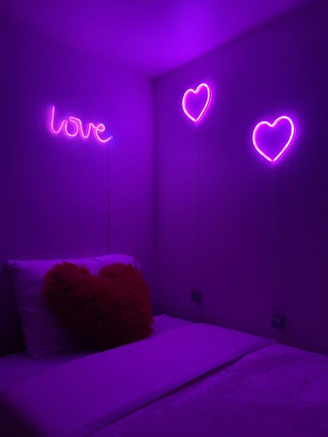 purple dimly lit room, white bed with red fluffy heart pillow, “love” pink neon light, two pink heart neon lights Neon Lights Bedroom Aesthetic, Heart Room Decor, Pink Room Design, Heart Room, Vibey Room Aesthetic, Vibey Room, Purple Room Decor, Neon Lights Bedroom, Pink Glitter Wallpaper