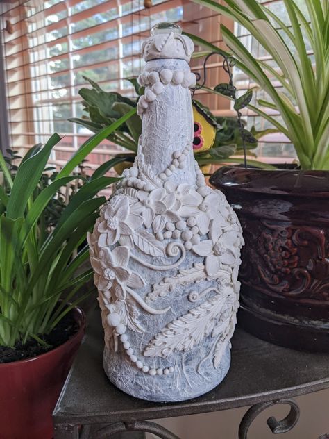 Try this idea next. Turn a plain bottle into a unique gift. Air Dry Clay Bottle Art, Air Dry Clay Bottle Art Ideas, Clay On Glass Bottles, Bottle Decoration With Clay, Air Dry Clay On Glass Bottles, Clay Bottle Art Ideas Flowers, Antique Bottle Art With Clay, Diy Glasses, Liquor Bottle Crafts