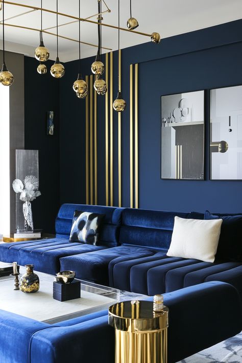 Looking for inspiration for your living room? Explore 25 stunning ideas that showcase the elegance of blue and gold. From bold statement walls to subtle accents, discover how to create a space that is both stylish and inviting. Find inspiration for your own blue and gold living room today. Blue Interiors Living Room, Bold Interior Design Living Room, Blue Gold Living Room Ideas, Modern Classy Living Room, Blue Gold Living Room, Royal Blue Living Room, Jonathan Adler Living Room, Gold Living Room Ideas, Blue Window Treatments