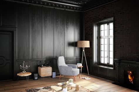 Dark living room with black full wainscoting and brick walls. It includes a gray chair lighted by a floor lamp over wood plank flooring. Dark Wood Paneling Walls, Wood Paneling Walls, Black Walls Living Room, Dark Wood Paneling, Black Room Design, Paneling Walls, Dark Ceiling, Black Living, Black Rooms