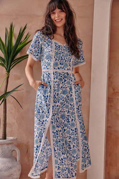 Serafina Blue Floral Cotton Midi Dress is a fusion of timeless elegance and contemporary charm. Crafted using traditional hand block printing techniques, this dress boasts a captivating blue floral print, a testament to the artistry and heritage of Indian textiles. This style is made from breathable cotton and features square neckline finished with buttons and bell sleeves. Side splits finished with delicate lace trim add a touch of femininity and movement as you walk. The lace trim complements Indian Textiles, Printed Cotton Dress, Cotton Midi Dress, Side Splits, Blue Floral Print, Block Printing, Printed Midi Dress, Side Split, Floral Midi Dress