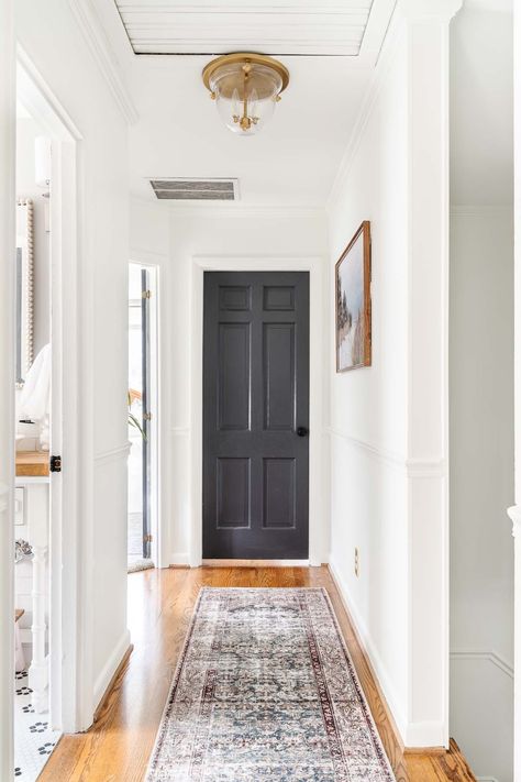 hallway painted with white wall paint and dark doors (Benjamin Moore Chantilly Lace and Benjamin Moore Wrought Iron) Best Colors For Hallways, Dark Doors In Hallway, Interior Paint Colors To Make House Look Bigger, White Walls Dark Doors, White Walls Colored Doors, Best Entryway Paint Colors, Hallway Door Colors, Painted Hallway Doors, Wrought Iron Benjamin Moore