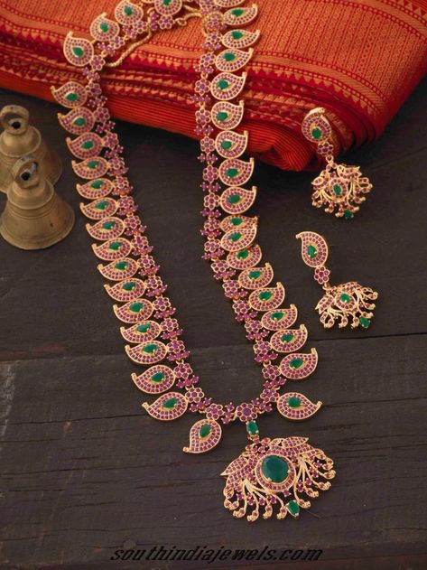 This imitation ruby emerald haram set is made of mango shaped motifs, each studded with tiny rubies and oval shaped emeralds. Kempula Haram Designs, Temple Indian, Mango Haram, Mango Mala, Haram Designs, Traditional Indian Jewellery, Long Pearl Necklaces, South Indian Jewelry, Pearl Jewelry Necklace