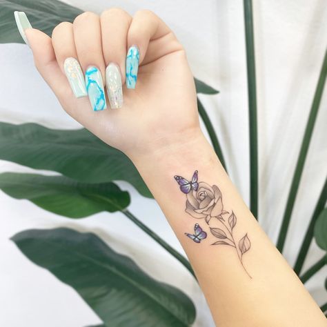 Forearm Daisy Tattoo Women, Tattoo Flower With Butterfly, Love Rose Tattoo, Butterfly Tattoo With Flowers Around It, Dainty Butterfly Tattoos, Small Rose And Butterfly Tattoo, Rose Tattoo With Butterflies, Wrist Butterfly Tattoo For Women, Tattoos With Flowers And Butterflies