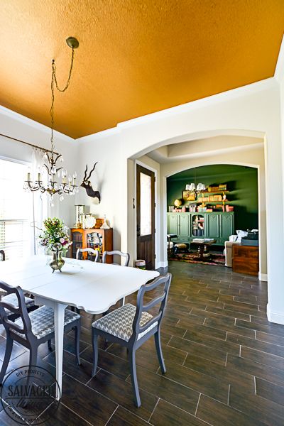 A plain dining room gets an upgrade to vintage glam with a gorgeous gold painted ceiling. See the best paint color for a metallic gold ceiling, perfect for a vintage dining room, classy master bedroom or stunning in a small bathroom. #5thwall #paintedceiling #ceilingcolor #metallicgoldpaint #diningroommakeover #vintagestyle Yellow Ceiling Dining Room, White Walls Color Ceiling, Dining Room Ceiling Mural, Mustard Yellow Ceiling, White Walls Painted Ceiling, Green Ceiling Dining Room, White Walls Colored Ceiling, Painted Living Room Ceiling, Vaulted Ceiling Paint