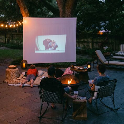 Family watching a movie outside on a projector around a fire pit Outdoor Movie Night Party, Summer Movie Night, Outdoor Movie Theater, Movie Birthday Party, Backyard Movie Nights, Fire Grill, Backyard Movie, Movie Night Party, Movie Birthday