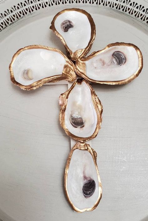 "Handcrafted oyster shell cross. Base is painted wood with oyster shells attached with gold gilding edges and backs.  Overall size 10\" high X 6 1/2\" wide x 1 3/4\" deep. Has a slotted hole on the back to hang or you can lean on a bookcase shelf or placed on a coffee table. Would be a lovely hostess or Birthday gift. A reminder of how blessed we are." Oyster Shell Cross On Wood, Art With Resin, Oyster Shell Crosses, Oyster Shell Cross, How To Paint Oyster Shells, Painted Oyster Shells Ideas, Oyster Shells Decor, Clear Gift Bags, Oyster Shell Crafts