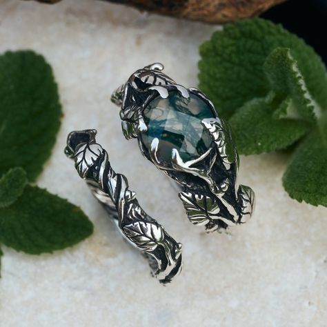 The "Sierra" ring, a vintage-inspired masterpiece, features intricately woven leaves and vines in oxidized sterling silver, framing a captivating rose-cut moss agate. This stunning statement ring, handcrafted with care, celebrates the beauty of nature and unique design.  The matching "Sierra" wedding band completes the set, showcasing a timeless elegance.  Expertly crafted in sterling silver with oxidized finish, each piece is 100% handmade and comes with express worldwide delivery and a lifetime warranty.  Ready to ship in 10 business days. Promise Ring Bands, Nature Themed Engagement Rings, Forest Wedding Rings, Natural Engagement Rings, Earthy Wedding Rings, Forest Wedding Ring, Moosachat Ring, Nature Inspired Wedding Ring, Forest Ring