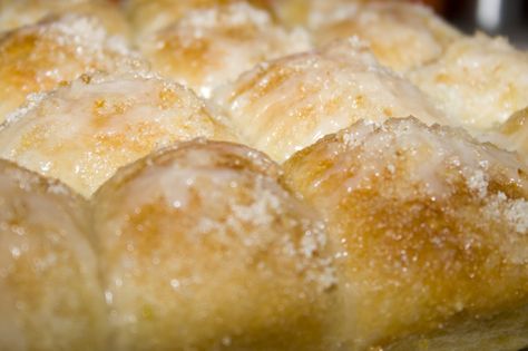 Lemon Monkey Bread  (from Creations by Kara)  12 Rhodes dinner rolls, thawed but still cold  zest of 1 lemon  1/2 cup sugar  3 tablespoons butter, melted  Glaze:  1/2 cup powdered sugar  1 Tbsp lemon juice  1. Cut rolls in half and place in a greased 9×13″ pan.  2. Drizzle with the melted butter.  3. Mix lemon zest and sugar together in a small bowl. Sprinkle HALF of the lemon sugar mixture over the rolls. Cover and let raise till doubled.  4. Sprinkle remaining sugar mixture on top. Bake at 350 Lemon Monkey Bread, Pull Aparts, Rhodes Rolls, Yeast Recipes, Dream Food, Recipe Dessert, Lemon Flavor, Sweet Rolls, Sweet Breads