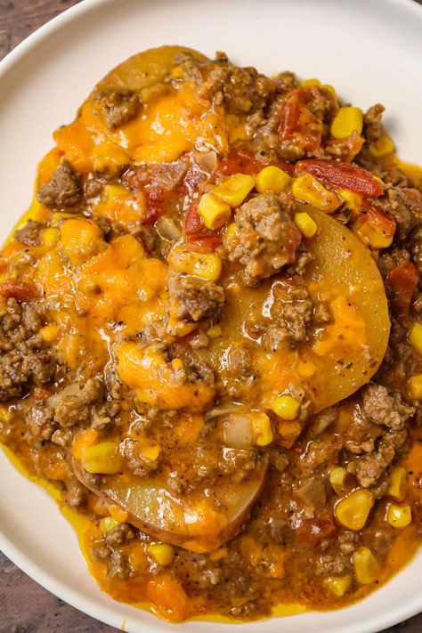 Crock Pot Cowboy Casserole is a hearty slow cooker dinner recipe loaded with ground beef, diced tomatoes, potatoes, corn and cheese. Slow Cooker Lumberjack Casserole, Crock Pot Inspired Recipes Ground Beef, Cowboy Hamburger Casserole Recipes, Slow Cooker Cowboy Supper, Slow Cooker Hobo Dinner, Easy Slow Cooker Stew Recipes, Beef And Potatoes Recipes Slow Cooker, Soup Recipes Slow Cooker Beef, Cowboy Lunch Ideas