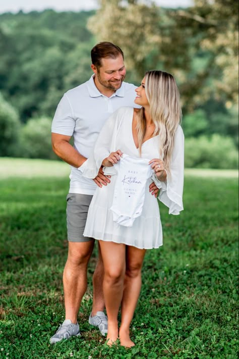 We're Pregnant Photoshoot, Maternity Photography With Onesie, Baby Announcement Photoshoot Summer, Pregnancy Announcement Poses Couple, Baby Announcement Couple Photos, Pregnancy Announcement With Onesie, Spring Pregnancy Announcement Photoshoot, Announcing Pregnancy Photoshoot, Outdoor Pregnancy Announcement