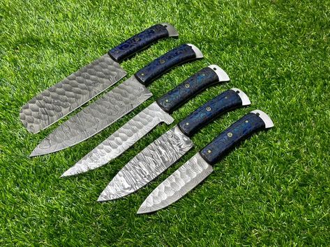 In the world of culinary arts, a handmade Damascus chef set of 5 knives is more than just a collection of kitchen tools; it’s a fusion of precision and design. These knives, with their exceptional sharpness, versatility, and the added elegance of leather sheaths, are not just utensils; they are extensions of your culinary creativity. Elevate your culinary craftsmanship and embrace the art of cooking with this extraordinary chef set. Women's Chef Jacket, Best Kitchen Knife Set, Damascus Chef Knives, Handmade Kitchen, Chef Knife Set, Kitchen Cutlery, Damascus Knife, Knife Design, Knife Set Kitchen