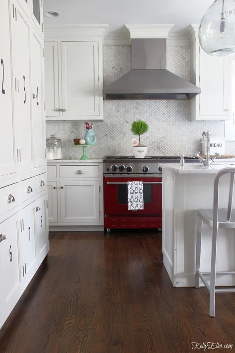 Love this red stove with white cabinets and marble backsplash kellyelko.com #kitchen #kitchendecor #kitchendesign #whitekitchen #appliances #ovens Kitchen With Red Stove, Red Stove Kitchen, Red Stove In Kitchen, Marble Herringbone Tile, Kitchen Counter Storage, Stove Kitchen, Marble Herringbone, Red And White Kitchen, Classic White Kitchen