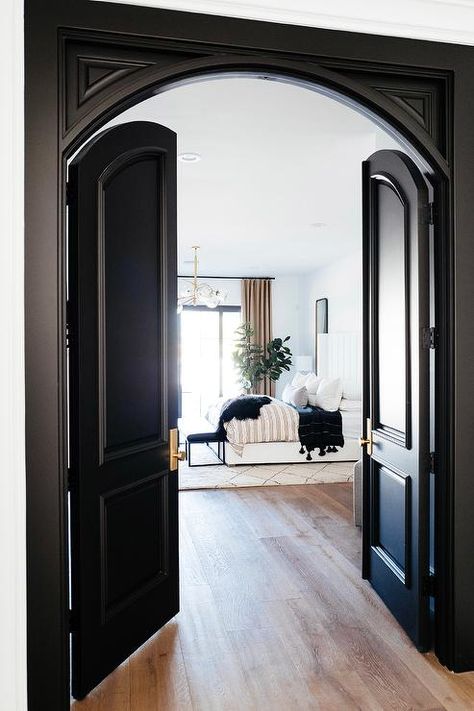 Black arch double doors to a master bedroom bring a classic appeal completed with brass doorknobs entering into a styled room. Pintu Ganda, Black French Doors, Formal Living Room Decor, Pintu Interior, Traditional Design Living Room, Black Interior Doors, Elegant Living Room Decor, Bedroom Minimalist, Bedroom Door Design