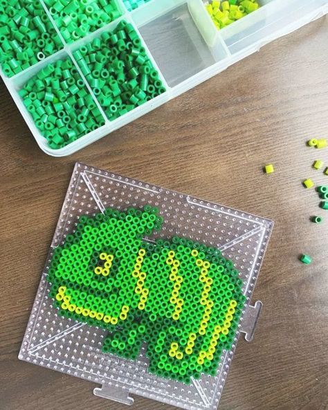 Need some cute melty bead ideas? If you like cute animals, then you’ll love making this adorable chameleon melty bead pattern. Is there an animal that you just know you could stop and watch for hours and not know any time has passed? That’s how I feel about chameleons. Even if you don’t like lizards, ... Read More about  Chameleon Melty Bead Pattern (free) Easy Perler Bead Patterns, Melty Bead Patterns, Pearl Beads Pattern, Fuse Bead Patterns, Art Perle, Arte 8 Bits, Hama Beads Design, Perler Bead Templates, Diy Perler Bead Crafts