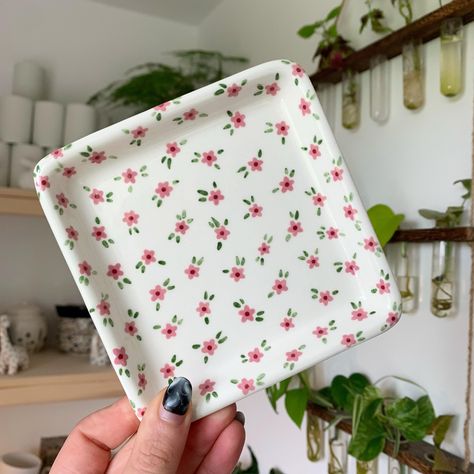 Square trinket tray with little pink flowers 🌸✨🌱 Lots of things available on my website now - link in bio ✨🥰 #art #artist #ceramics #pottery #painting #illustrator #ceramicstudio #potterytiktok #potterypainting #painter #trinkettray #smallbusiness Jewelry Tray Painting Ideas, Trinket Tray Painting Ideas, Pottery Painting Jewelry Dish, Pottery Trinket Dish, Floral Pottery Painting, Tray Painting Ideas, Painted Trays Ideas, Ceramic Painting Ideas Plates, Tray Painting