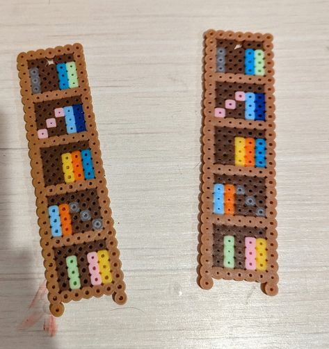 A bookshelf shaped bookmark. Hama Beads Bookmark Ideas, Cute Perler Bead Bookmarks, Perler Bead Book Mark Patterns, Fuse Beads Bookmark, Peeler Bead Bookmark, Pearler Bead Bookmark, Book Perler Beads, Perleplader Ideas Diy, Bookmark Perler Beads