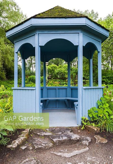 Blue painted wooden gazebo with built-in sitting benches and cedar shingles covered in green Bryophyta - Moss overlooking pond in summer, Centre de la Nature public garden, Saint-Vincent-de-Paul, Laval, Quebec, Canada Painted Gazebo, Wooden Gazebo, Cedar Shingles, Slate Roof, Saint Vincent, Plant Photography, Public Garden, Quebec Canada, Blue Paint