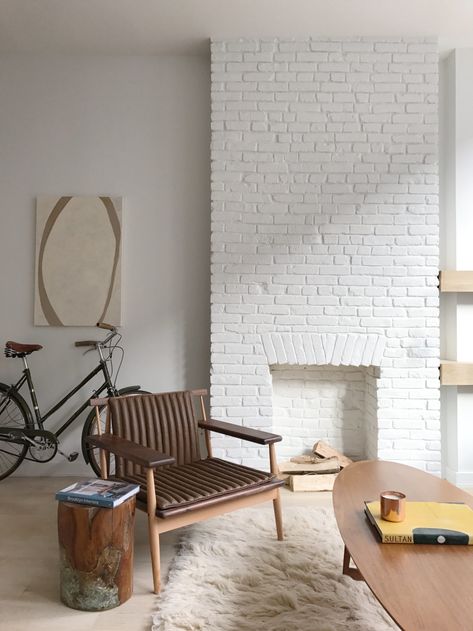 white painted brick fireplace | Whitewashed simplicity courtesy of Benjamin Moore’s Decorator’s White in another Williamsburg condo. White Painted Chimney, White Brick Walls Interior, White Brick Painted Fireplace, Painted White Brick Interior, Painted Interior Brick Wall Ideas, White Painted Brick Interior Wall, White Brick Basement, Painted White Brick Wall, Brick Wall Paint