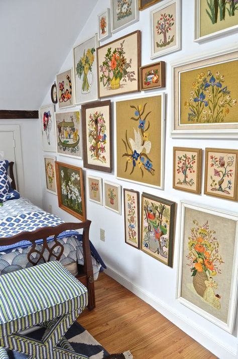 Guest bedroom with mixed patterns and textures. Gallery wall of embroidered art. Cute Wall Bedroom Ideas, Wall Of Framed Pictures, Folk Style Living Room, Vintage Crewel Gallery Wall, Vintage Framed Embroidery Wall Art, Framed Art Wall Bedroom, Bedroom With Frames Wall Art, Mid Century Gallery Wall Ideas, Paintings On Bedroom Walls