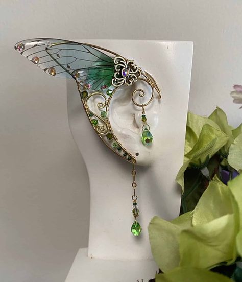 This Pair of Handcrafted Ear wraps with Wings has been created using Brass Wires, and Peridot Swarovski Crystals. They are Comfortable and easy to wear with a Hoop on the back making it easy to adjust; Perfect for any Festive event, Cosplay, or night out on the Town. All Items are made to order. If you have something Special in mind… Please Contact us… We Love Custom Orders. Fairy Wings Inspiration, Cicada Wings Open, Fairy Ears Aesthetic, Crystals Outfit, Fae Jewelry, Forest Fairy Wings, Fairytale Accessories, Fairy Items, Fantasy Accessories