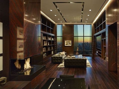 Stepping into the library, a dramatic scene of dark wood and dim lighting is topped off with a red marble fireplace. A massive wine room follows, with storage space of up to 2,000 bottles. Penthouse Library, Penthouse In New York, Double Height Living Room, Manhattan Penthouse, Penthouse Interior, Nyc Penthouse, New York Penthouse, Luxury Penthouse, Expensive Houses