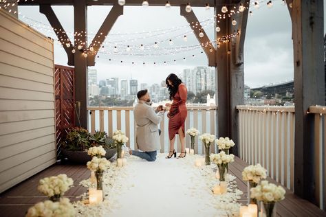 Stunning set up done by my proposal co. Proposal consists of a white carpet aisle lined with candles, vases filled with white roses and accompanied with white rose petals. Warm fairy lights filled the balcony at Pier One to create a romantic atmosphere. #luxuryproposal #proposalspecialists #proposalideas #proposal #marriageproposal #engaged #diamondring #pieronesydney #whiteroses #balcony Poolside Proposal Ideas, White Proposal Decor, All White Proposal Decor, Balcony Proposal Ideas, Rose Petal Proposal, White Roses Proposal, Proposal Set Up Ideas Outside Winter, White Rose Aisle, White Rose Proposal