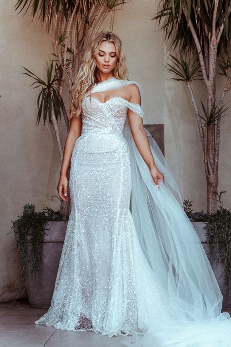 For a whimsical and bold statement our Galia Lahav couture #Simone mermaid wedding dress is beautifully embroidered with scattered pearls and shimmery sequins and has added romance with a sheer cape that attaches to the sweetheart neckline. Mermaid Wedding Dress With Cape, Shimmery Wedding Dress, Galia Lahav Bridal, Elegant Bridal Dress, Sheer Cape, 2024 Bride, Wedding Swag, Fairy Wedding Dress, Wedding Dress Cake