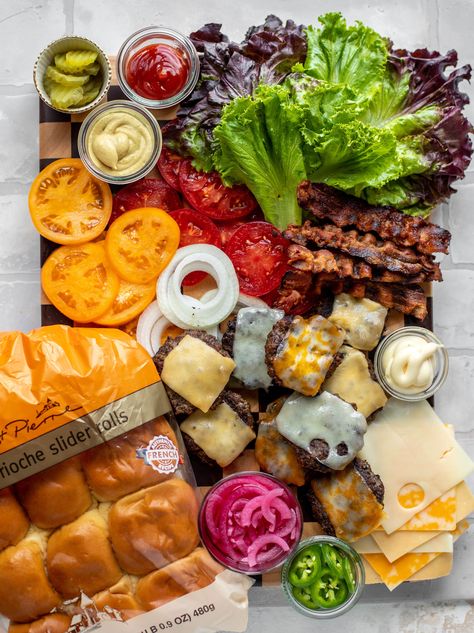 This slider bar is a great way to serve burgers to your family and friends! Load up on toppings, vegetables and condiments. It's so fun! #st.pierre #sliders #burgerbar #briochesliderrolls  howsweeteats.com Burger Slider Bar, Burger Bar Charcuterie, Build Your Own Kabob Bar, Sliders Board Ideas, Slider Bar Ideas Parties, Slider Bar Wedding, Burger Party Ideas Food Bars, Slider Charcuterie Board, Slider Toppings