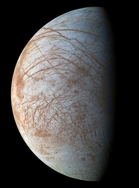 Jupiter’s moon Europa. Image Credits: NASA/JPL-Caltech. NASA laboratory experiments suggest the dark material coating some geological features of Jupiter’s moon Europa is likely sea salt from a subsurface ocean, discolored by exposure to radiation. The presence of sea salt on Europa’s surface suggests the ocean is interacting with its rocky seafloor – an important consideration in determining whether the icy moon could support life. Jupiter Moons, Planets And Moons, Nasa Jpl, Dark Material, Space Images, Our Solar System, To Infinity And Beyond, Space And Astronomy, Deep Space