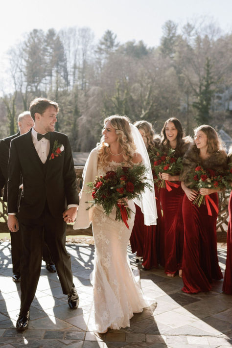 Bride and Groom holding hands in front of bridesmaids wearing red dresses Mother Of The Bride Christmas Wedding, Winter Wedding Party Outfit, December Wedding Groomsmen, Christmas Groomsmen Attire, Christmas Wedding Party Attire, Christmas Wedding Bridal Party, Christmas Wedding Photos, Winter Groomsmen Attire, Christmas Wedding Attire