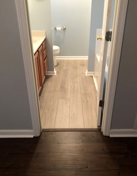 Coretec's Hearthscapes Collection includes beautiful luxury vinyl tile products that are both waterproof and stunning in detail. This LVT in mango oak is light in color and looks beautiful next to the darker wood outside of the bathroom. Great job Willie! Laminate Wood Bathroom Floor, Wood Laminate In Bathroom, Wood Vinyl Bathroom Floor, Bathroom With Laminate Flooring, Hardwood To Vinyl Plank Transition, Lvt In Bathroom, Dark Wood Bathroom Floor, Lvp Bathroom Floor, Bathroom Flooring Ideas Vinyl