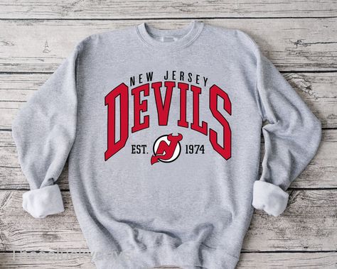 Vintage Nj Devils Hockey Apparel And Merchandise T-Shirt Check more at https://customizationtrend.com/vintage-nj-devils-hockey-apparel-and-merchandise-t-shirt-2368/ New Jersey Devils Outfit, New Jersey Sweatshirt, New Jersey Devils Merch, Hockey Apparel, Streetwear Hockey Jersey, Hockey Sweater, College Sweater, Hockey Sweatshirts, Hockey Shirts