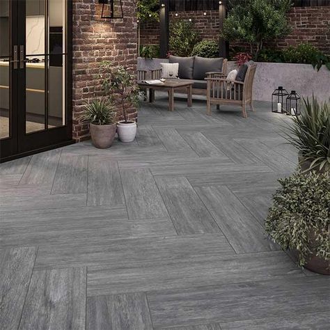 Experience the beauty of natural wood with our Forest Grey range, redefining your outdoor space in a resilient and captivating grey hue. These garden slabs, available in a textured plank format, offer versatility in styling, allowing for creative layouts in patios, raised areas, or as plank stepping stones amidst grass or gravel.  Unlike timber, our external porcelain tiles provide the beauty of wood without the need for sealing, ensuring durability and eliminating concerns of rot or slipperines Wood Effect Garden Tiles, Timber Look Tiles Outdoor Patio, Open Terrace Tiles Design, Veranda Tiles Floors, Tiles For Veranda, Tiled Outdoor Area, Outdoor Porcelain Tile Patio, Outdoor Patio Tile Ideas, Terrace Flooring Ideas