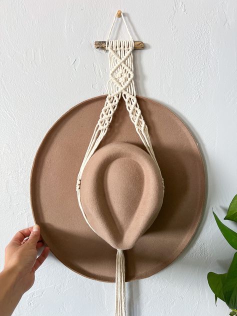 Display your favorite hats with a boho chic macrame hat holder! Handmade with central coast driftwood & natural cotton string. There are two different styles, a single tier & a double tier! Single Hat Hanger Dimensions The driftwood piece: 4 to 5" Length (with hat): approx. 32" Double Hat Hanger Dimensions The driftwood piece: 4 to 5" Length (with hats): approx. 46" Turnaround time + shipping Every hat hanger is handmade to order! Please allow for 3-5 business days before it ships off to you. Cu Macrame Boho Hat Hanger, Macrame Plate Hanger, Macrame Hat Holder Tutorial, Simple Macrame Hat Hanger, Hat Hanger Macrame, Macrame Cowboy Hat Holder Diy, Macrame Hat Hanger Diy Pattern, Macrame Cowboy Hat Holder, Macrame Hat Hanger Diy