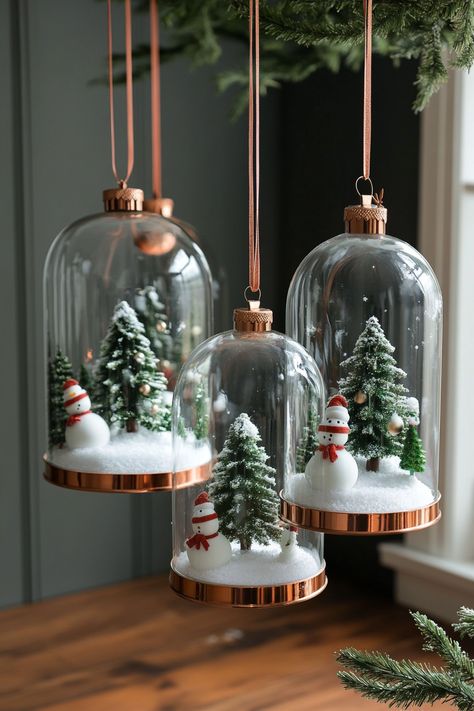 Six glass cloches with snowy Christmas scenes, set against dark grey walls and light wooden floor, adorned with greenery. Christmas Cloches Decor Ideas, Glass Dome Decor Ideas, Christmas Cloche Ideas, Ice Princess Party, Glass Cloches, Trendy Christmas Decor, Cloche Decor, Festive Table Setting, Dark Grey Walls