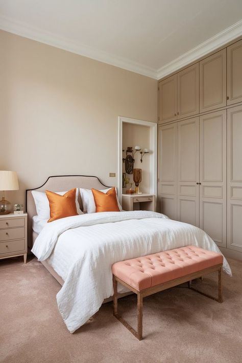 Bedroom with a queen-size bed, white duvet, orange pillows, nightstand with lamp, wardrobe opposite the bed, beige walls, and light brown carpet. Bedroom Design With Wardrobe, Light Brown Carpet, Sleek Wardrobe, Stylish Bedroom Design, Brown Carpet, Brown Bedroom, Beige Tones, White Duvet, Perfect Bedroom