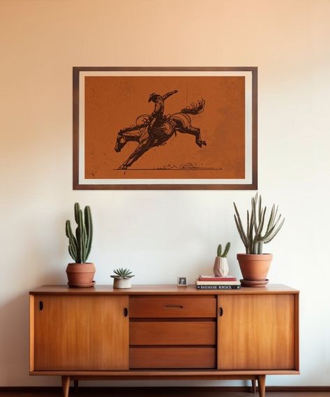 Feel the rush of the rodeo with our "Rodeo Star" print, a masterful depiction of a cowboy in perfect harmony with his spirited bronco. This line art piece is an ode to the raw, exhilarating moments that define the Western way of life. Artwork Features: -Dynamic Action: Each line thrums with the energy of a cowboy in the midst of a daring ride. -Western Motif: Embrace the classic symbolism of cowboy culture with a modern artistic twist. -Quality Craftsmanship: Created on substantial 10.3 mil matte paper, ensuring longevity and a premium finish. Choose from our specially curated range of sizes to fit your space: - 8x10 inches -11x14 inches -12x16 inches -12x18 inches -16x20 inches -18x24 inches -24x36 inches Whether it's for a Western-themed room, a gift for a rodeo enthusiast, or to bring a Western House Living Room, Modern Cowboy Decor Bedroom, Cowboy Aesthetic House, Cowboy Apartment, Cowboy Apartment Decor, 70s Western Aesthetic Home, Western Modern Living Room, Western Cottagecore Decor, Modern Western Office