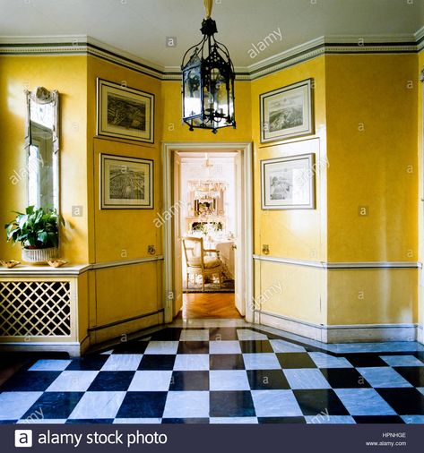 Download this stock image: A hallway with yellow walls and checkered flooring. - HPNHGE from Alamy's library of millions of high resolution stock photos, illustrations and vectors. Yellow And White Hallway, Yellow Victorian Hallway, Yellow Hallway, Checkered Flooring, Harlem Apartment, Arranging Furniture, Coved Ceiling, Mahogany Paneling, Old Lanterns