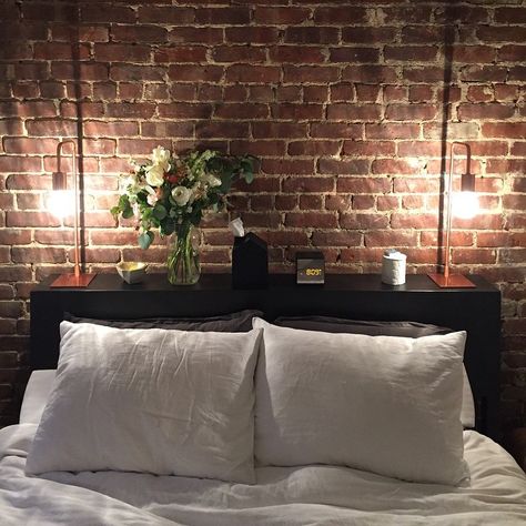 We love our bedding against this simple headboard and stunning exposed brick wall. Photo via Quinnate. Exposed Brick Walls Bedroom, Brick Bedroom Ideas, Exposed Brick Bedroom, Bedroom Brick Wall, Wall Headboard Ideas, Brick Wall Bedroom, Wall Behind Bed, Brick Bedroom, Brick Wall Decor