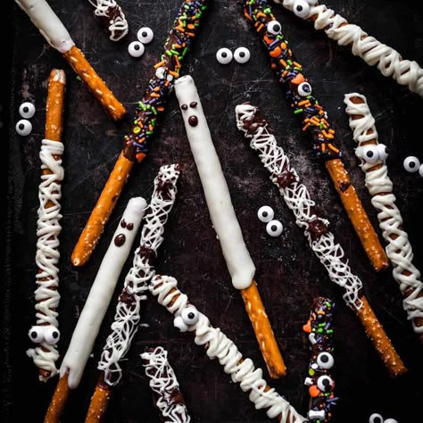 Halloween Themed Pretzels, Spooky Pretzel Rods, Ghost Pretzel Rods, Halloween Choc Covered Pretzels, How To Dip Pretzel Rods In Chocolate, Chocolate Dipped Pretzels Halloween, Chocolate Covered Pretzel Rods Halloween, Halloween Chocolate Pretzels, Halloween Dipped Pretzel Rods