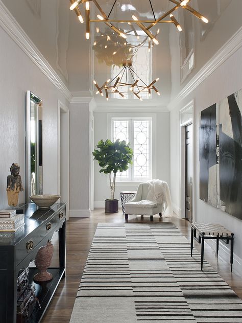 A high-gloss lacquered ceiling reflects the dramatic entry gallery. Entrance Hall Furniture, Transitional Entry, Modern Entryway Decor, Hall Furniture, The World Of Interiors, Modern Entryway, Entry Way Design, Modern Hallway, Hall Design