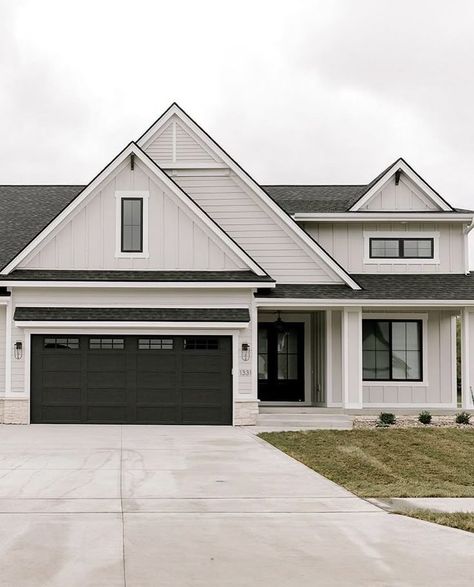 Grey House White Garage Doors, Light Grey Vertical Siding, White Garage Exterior, White House Dark Grey Roof, Tan Black House Exterior, Light Gray And Dark Gray House Exterior, Black Vs White House Exterior, Light Grey Houses Exterior, Exterior House Colors With Light Grey Roof